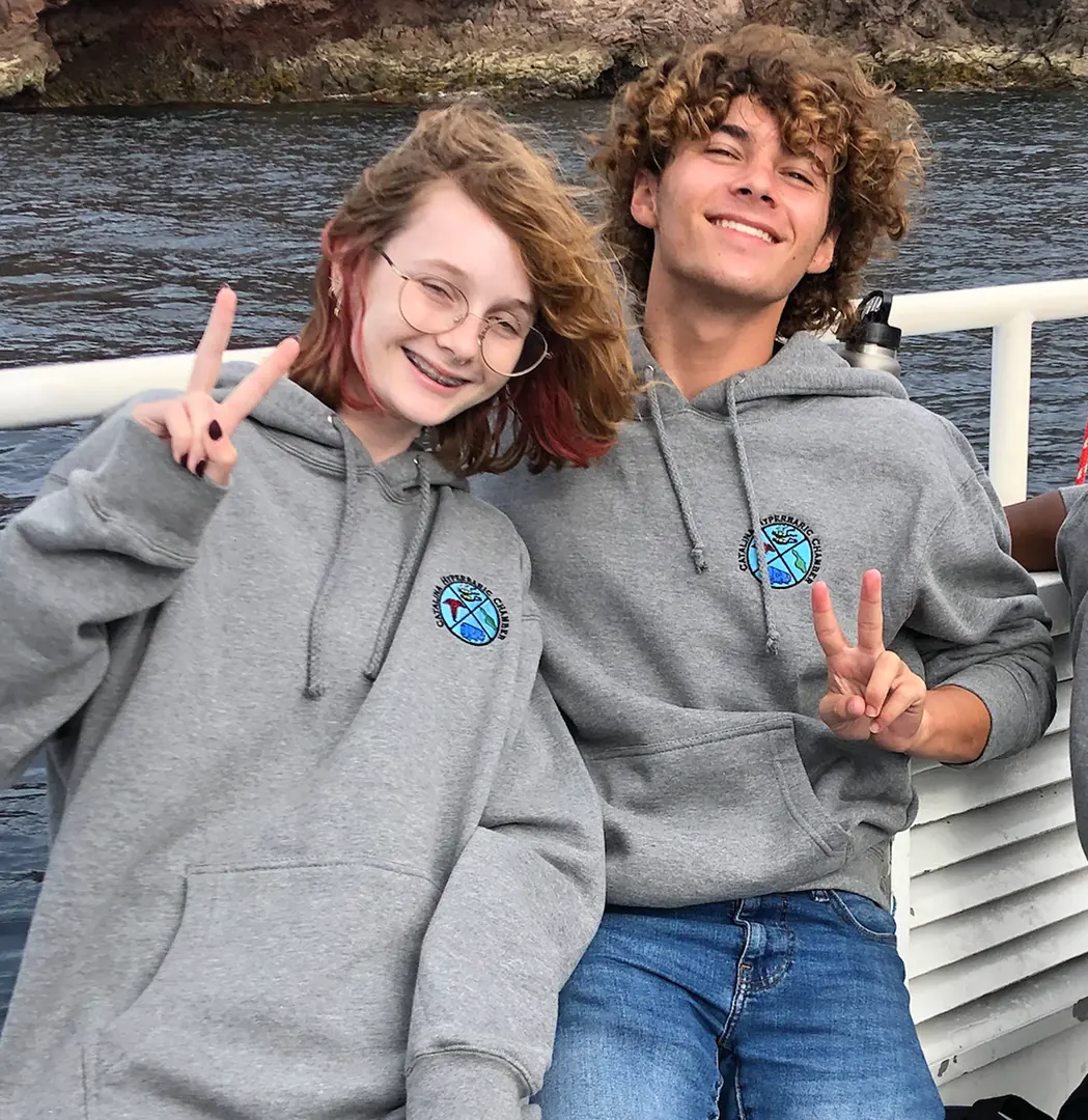 Students on boat posing with peace signs
