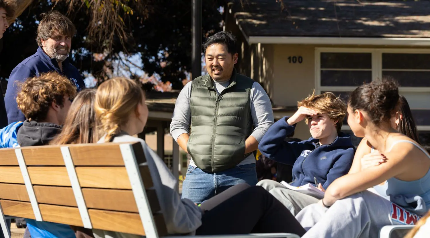 Chadwick teacher converses with students on Vanderlip Lawn.