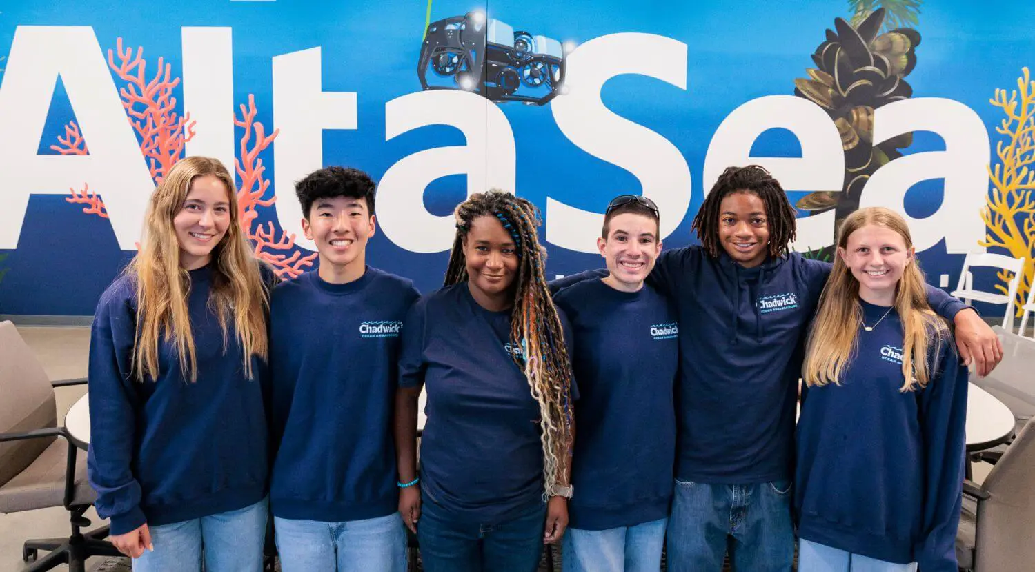 Upper School students posing in front of Alta Sea sign at the Chadwick School Ocean Institute Community Learning Lab in San Pedro.