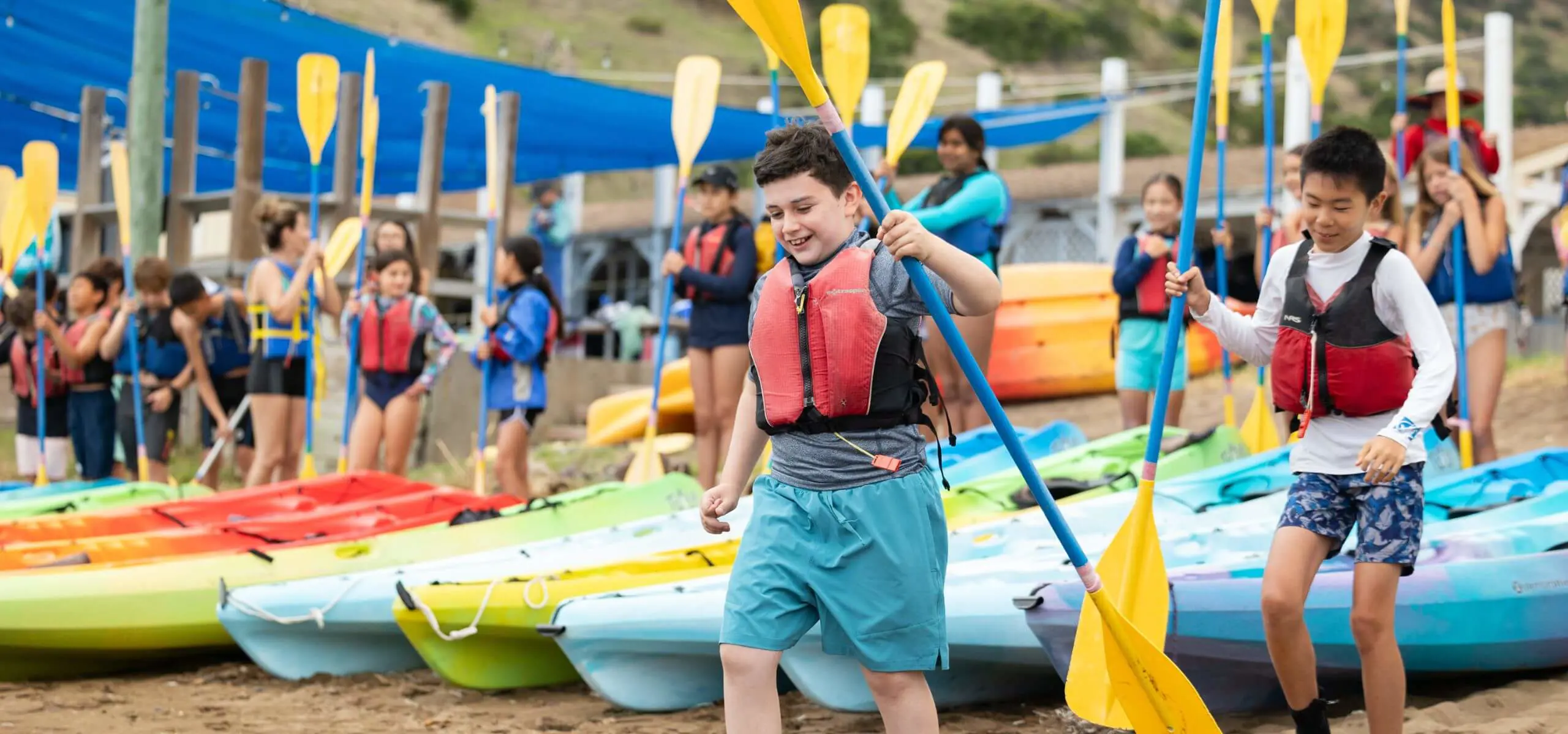 Students in helmets and life jackets prepare to launch their kayaks at Catalina Island.