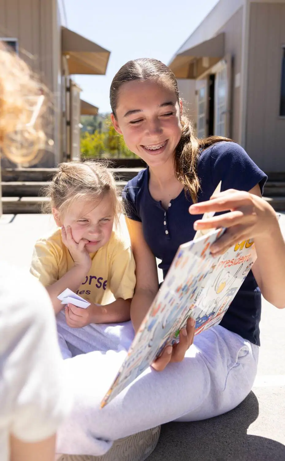 An Upper Schooler in the Community Service program Bookworms reads a book to Kindergartners on April 29, 2025.
