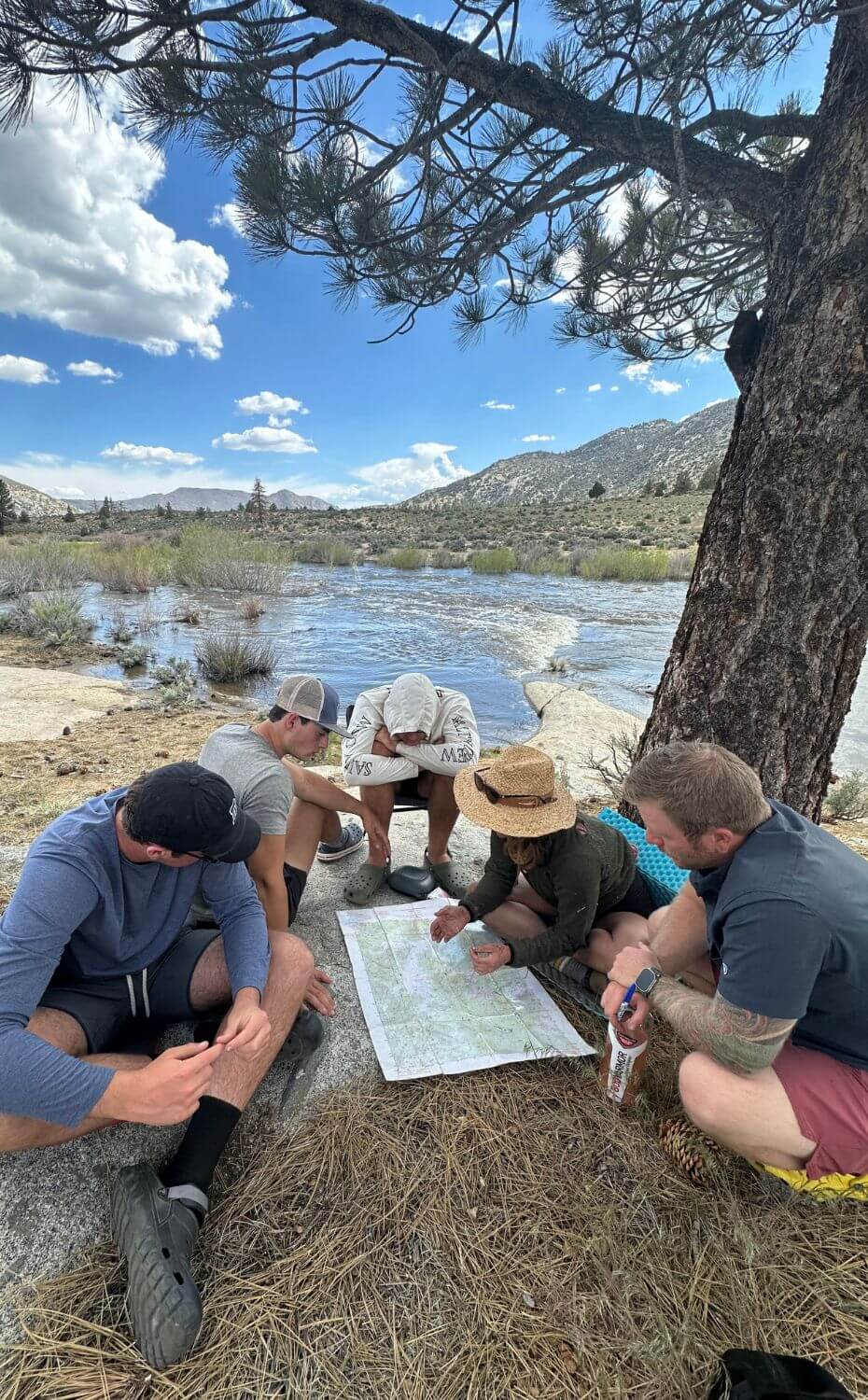 Senior Students study a map beneath a tree while on the senior Outdoor Education Trip.