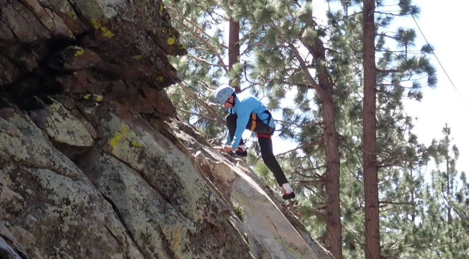 Senior student scaling a cliff-face with climbing gear on the Senior Outdoor Education trip.