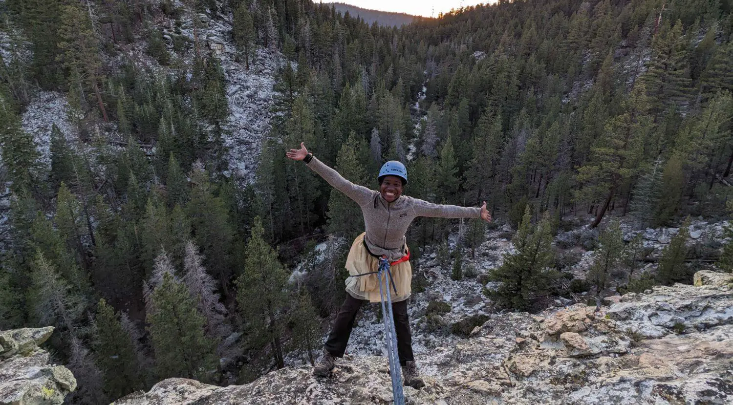 Senior student posing for a photograph after climbing a cliff-face on the Senior Outdoor Education trip.
