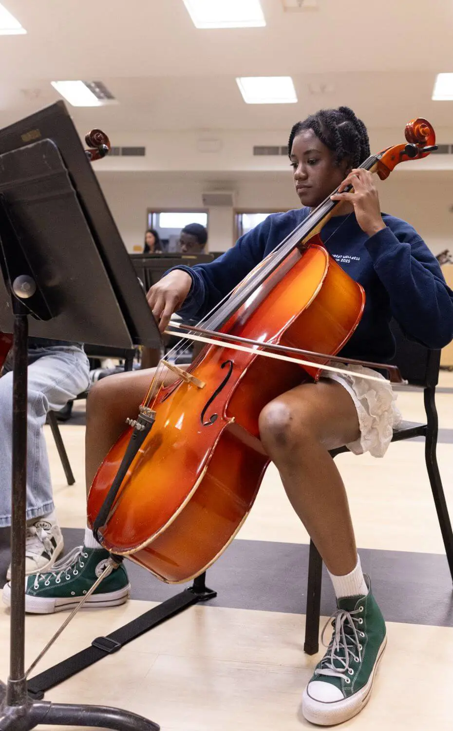 Upper School student playing the cello in orchestra.