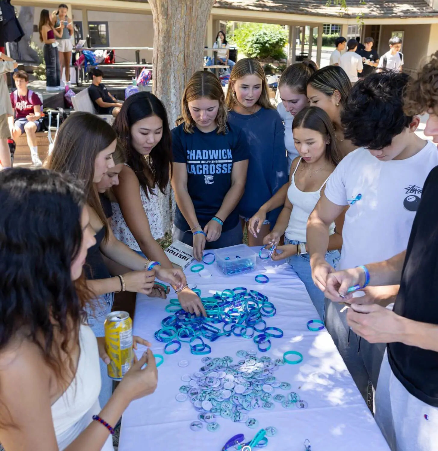 Students gather around a table with awareness bracelets on it.