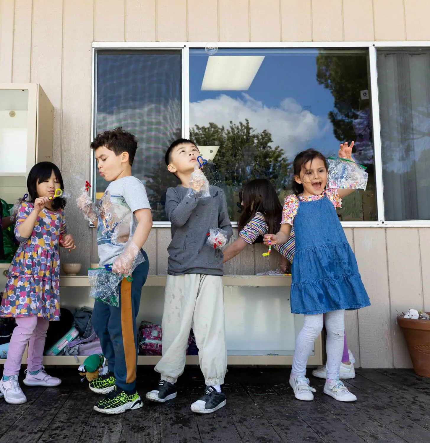 Village students blow bubbles outside of class during recess.