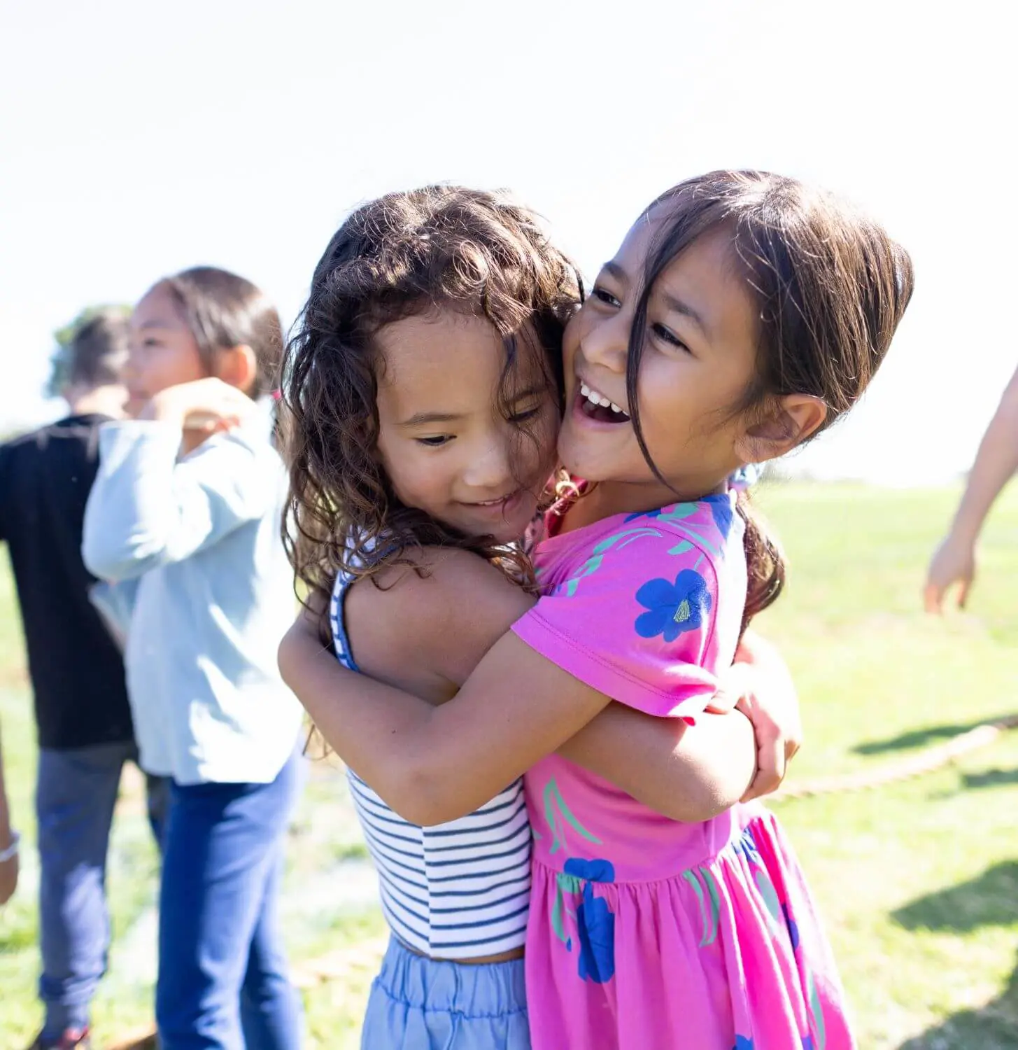 Two Village students embrace on Lichtenstein Family Field.
